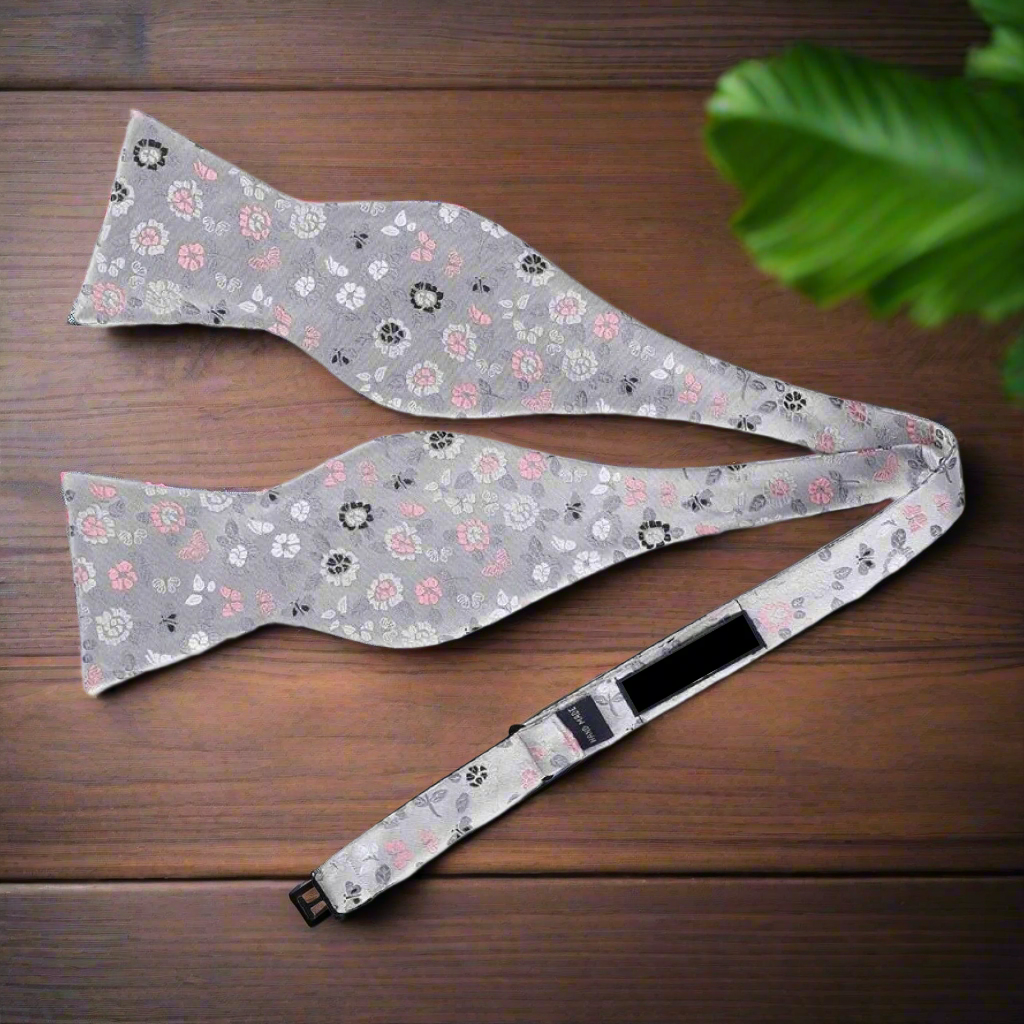 Light silver floral bow tie with delicate pink and blue accents, ideal for spring events.