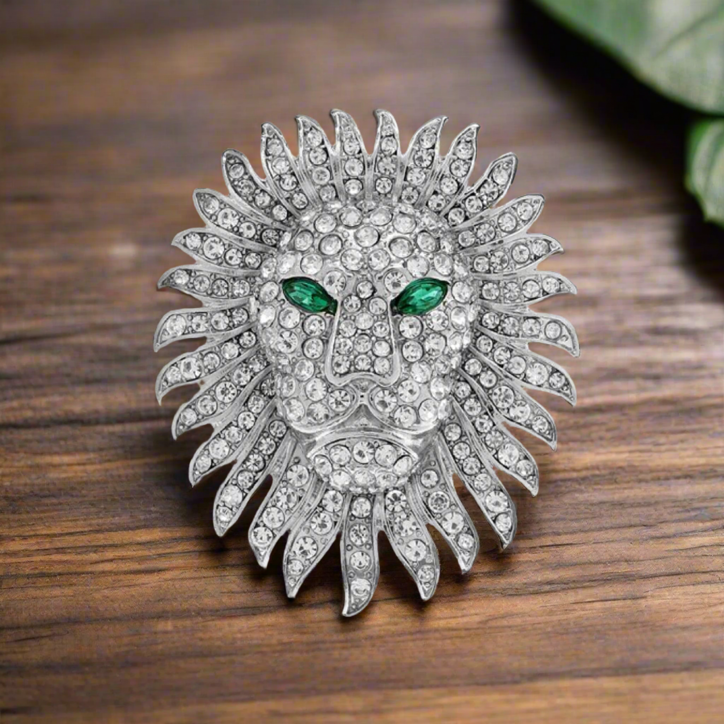 Gold lion head gemstone lapel pin displayed against a light background, emphasizing its luxurious appeal.