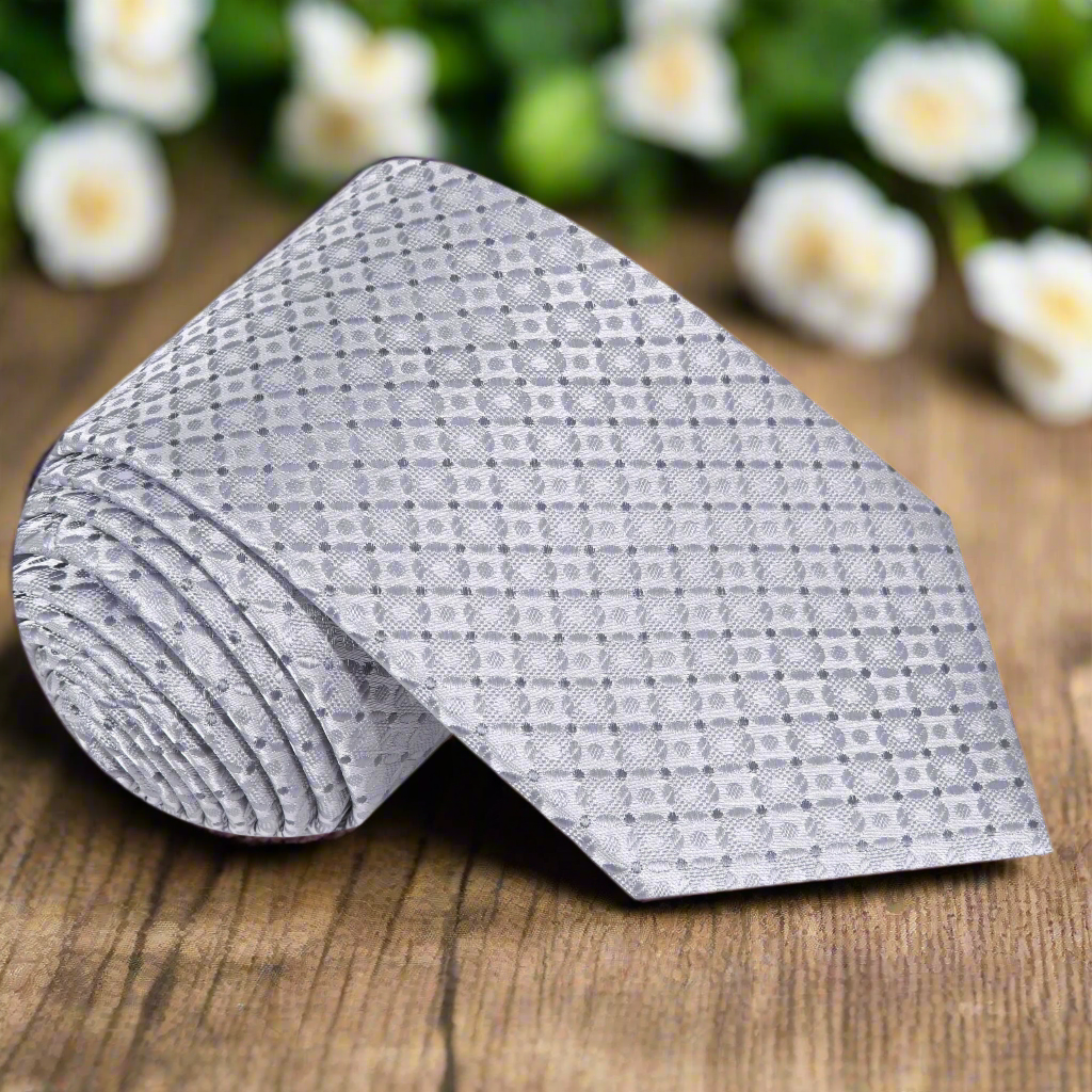 Elegant silver geometric necktie displayed on a crisp white shirt, perfect for business presentations.
