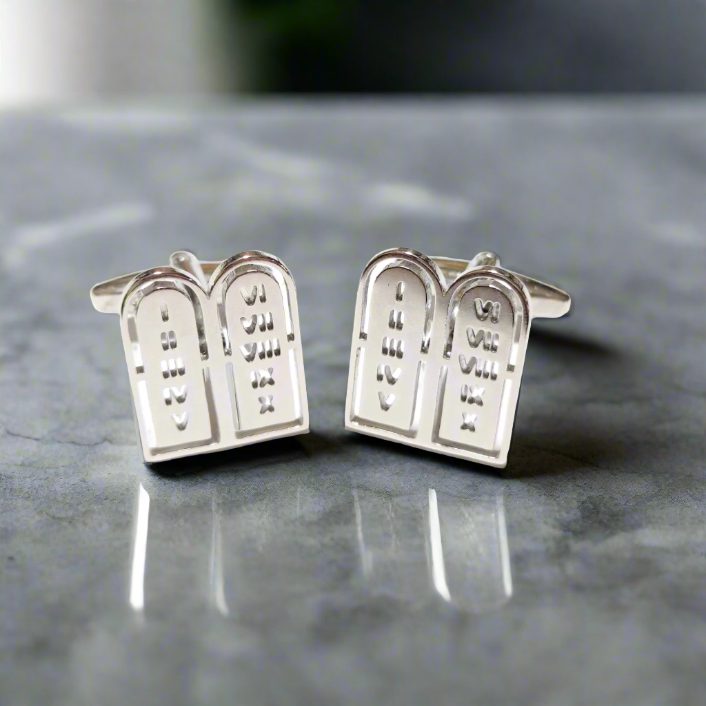 Close-up of chrome Roman numeral cufflinks with Ten Commandments engraved