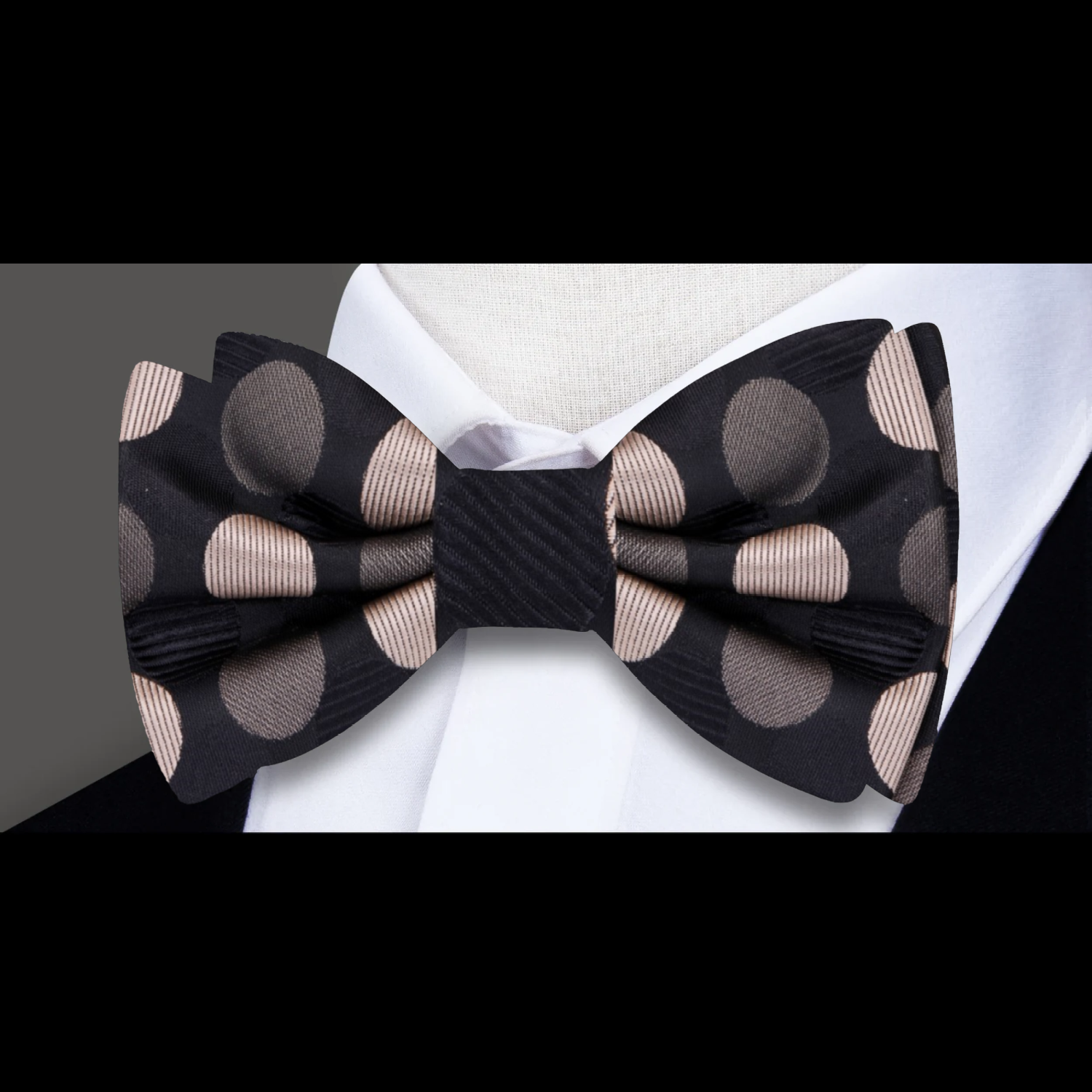 Elegant gold accented polka dot silk bow tie displayed on a suit