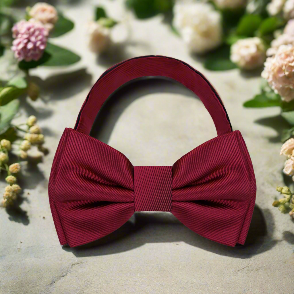 Elegant burgundy solid color bow tie paired with a crisp white shirt.