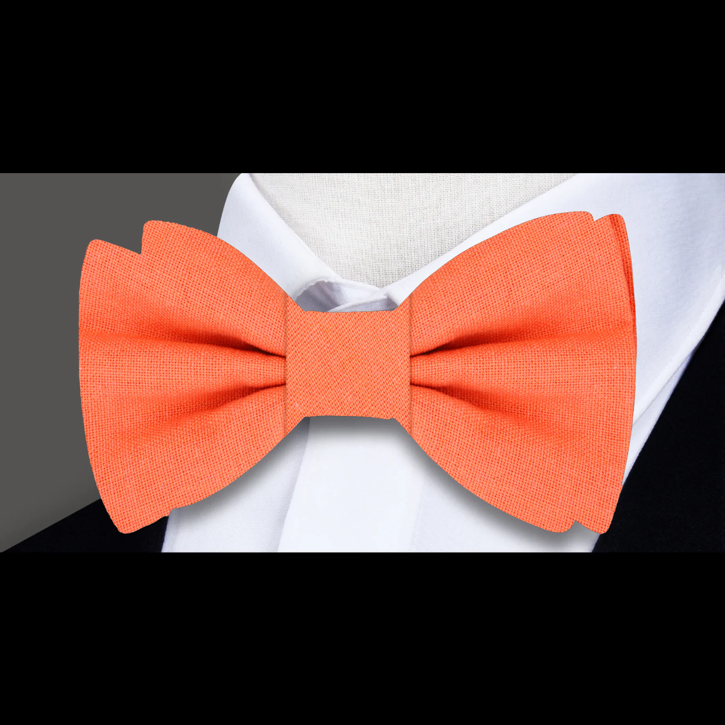 Groom wearing a navy linen bow tie with pocket square at a wedding reception