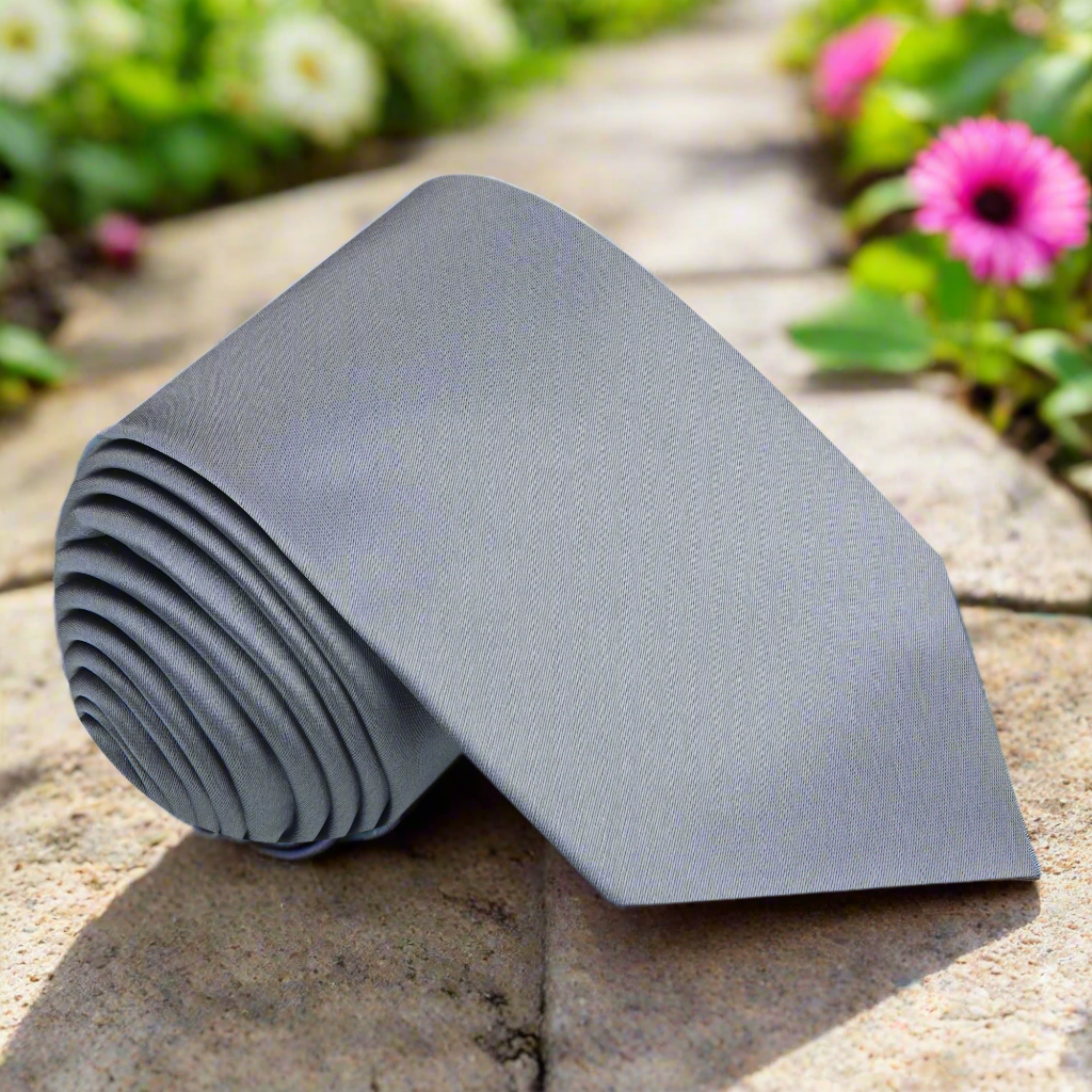 Timeless silver silk necktie displayed with a crisp white dress shirt, perfect for weddings.