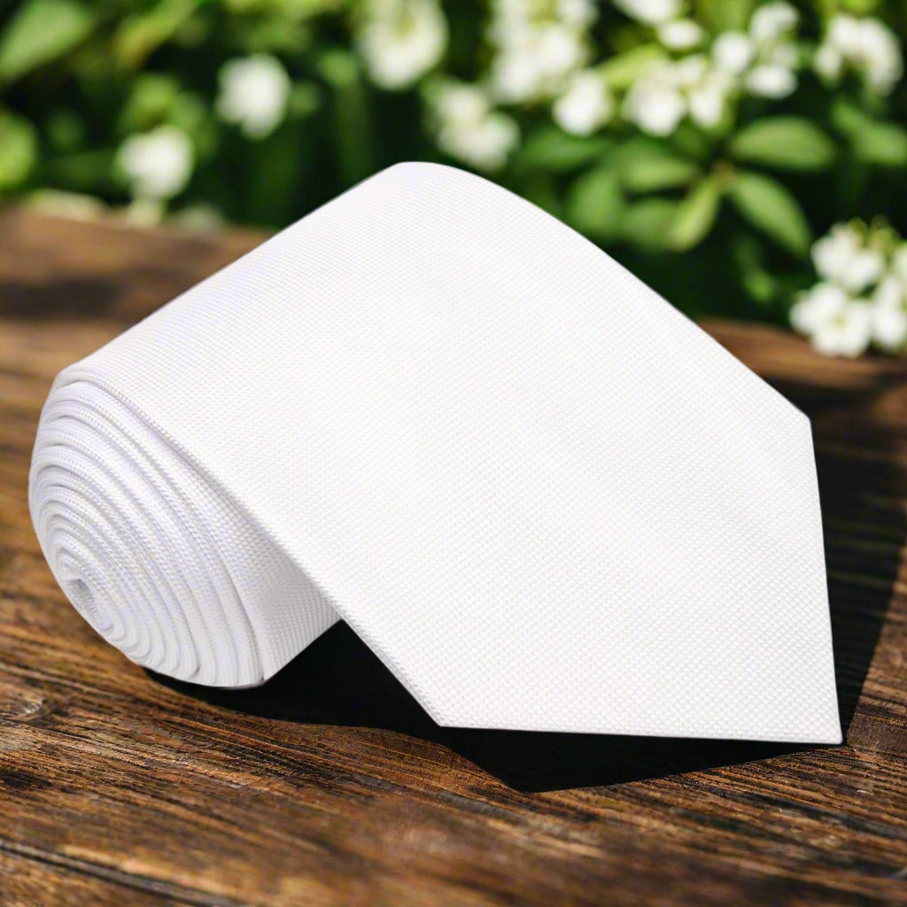 Elegant white necktie displayed on a tailored suit, ideal for formal wear.