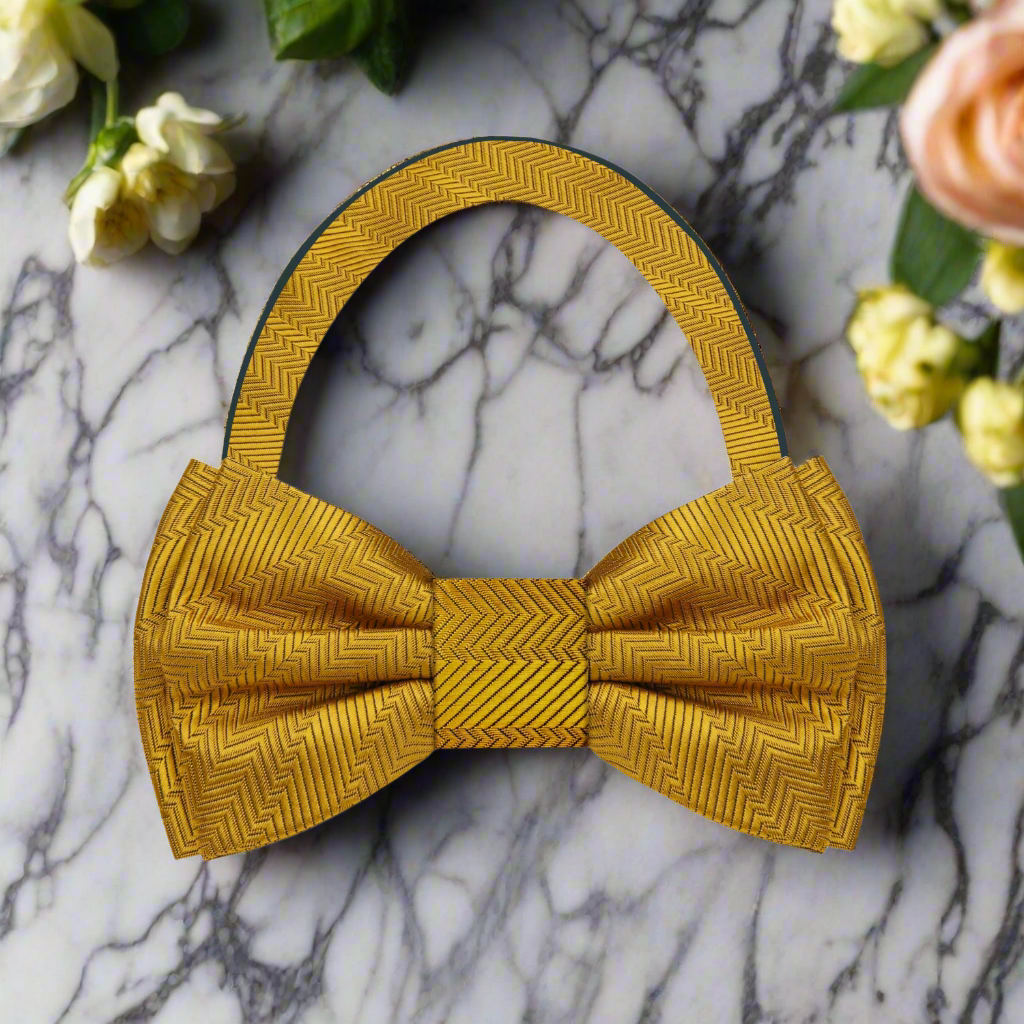 Elegant yellow bow tie with pocket square displayed on a light grey suit.