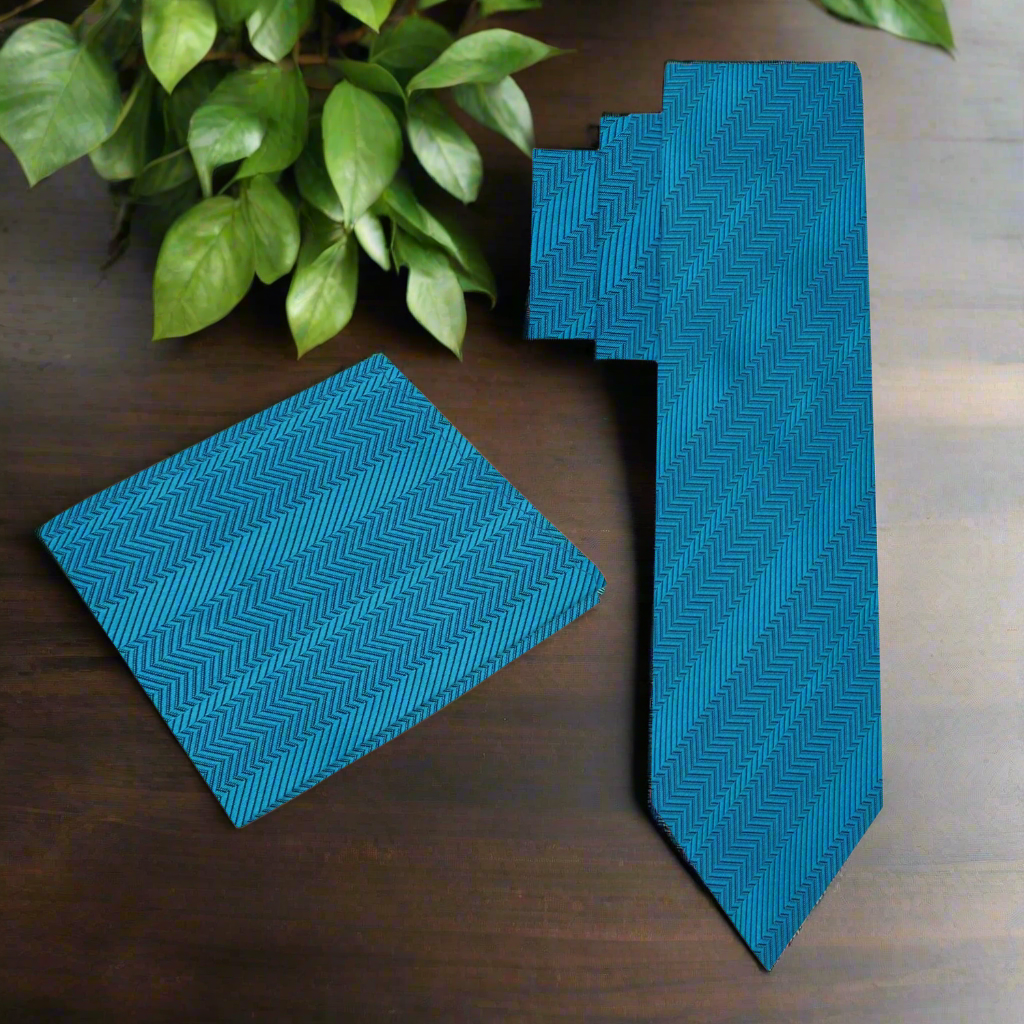 Close-up of the teal tie against a light grey dress shirt, highlighting the color contrast.