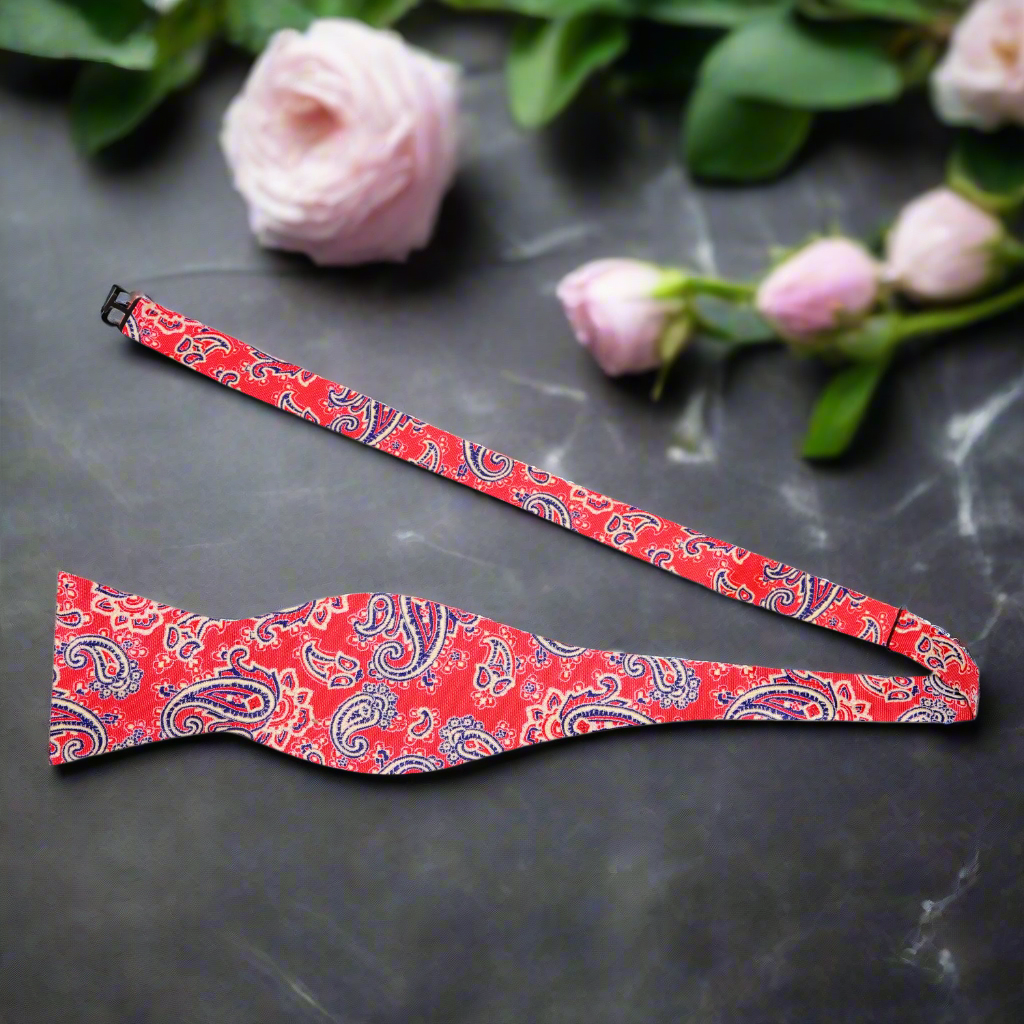 Close-up of a colorful pre tied bow tie with pocket square in vibrant paisley pattern.