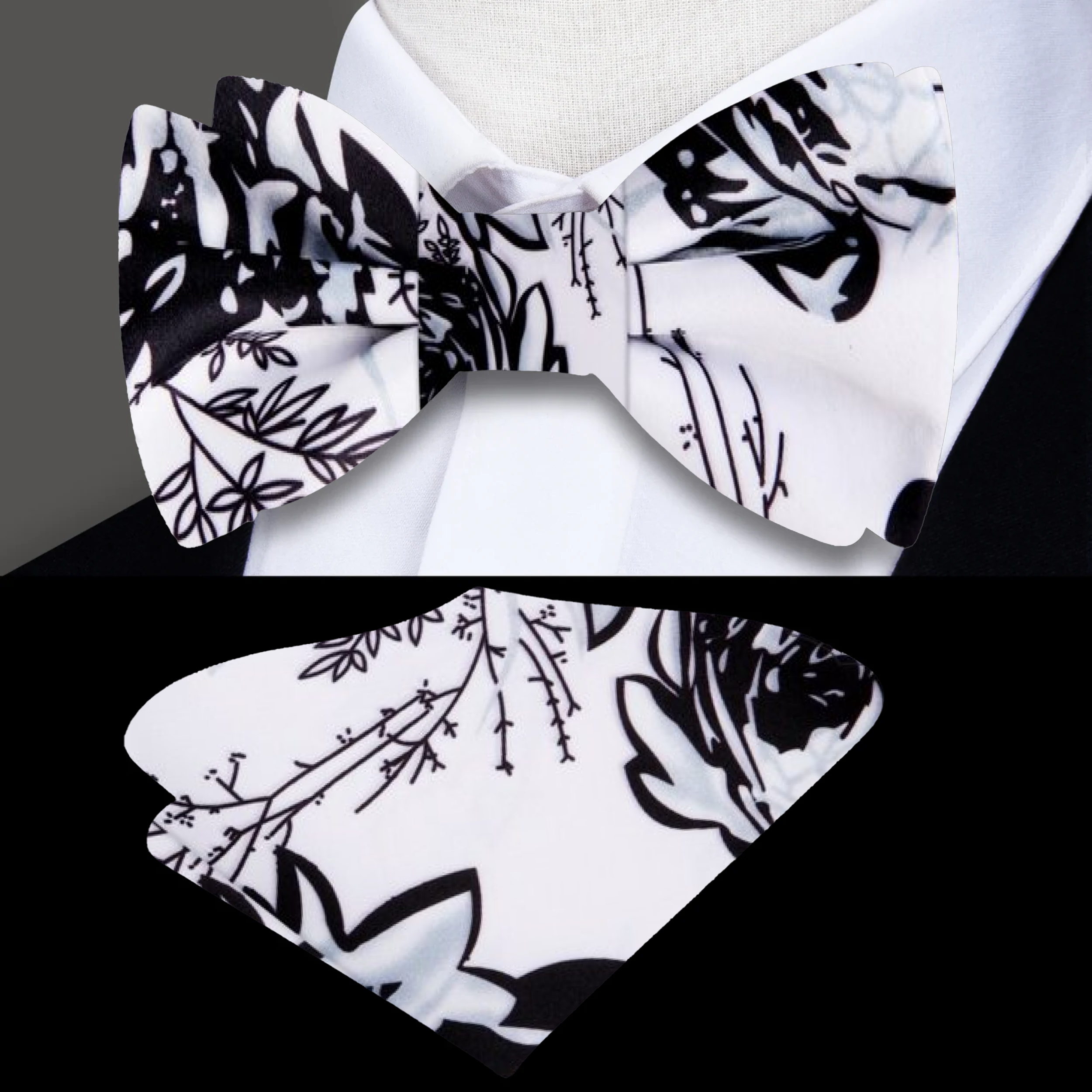 Close-up of artistic floral bow tie with black sketched flowers on white silk fabric