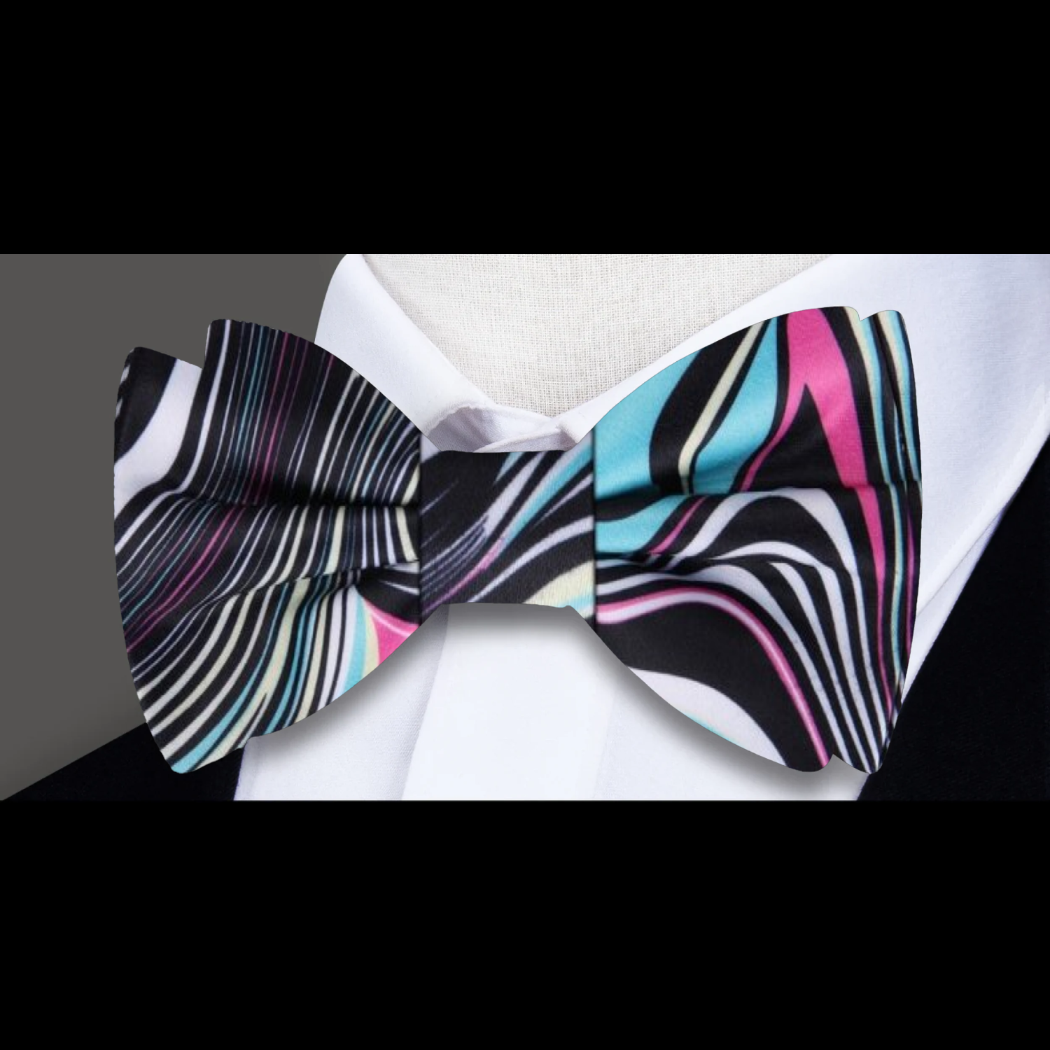 Close-up of vibrant abstract swirl silk bow tie on model