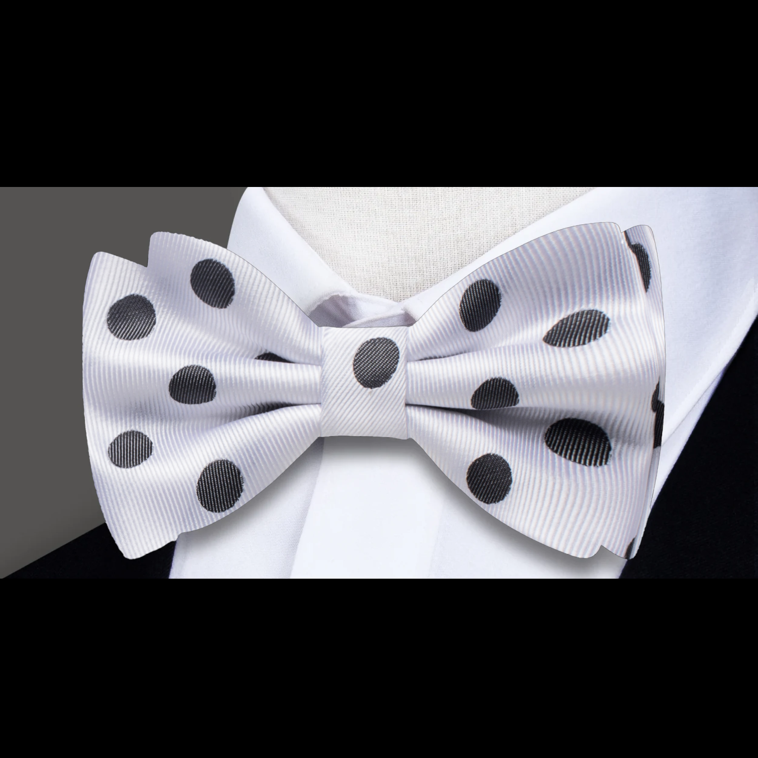 Light grey polka dot bow tie paired with a navy suit for a business dinner