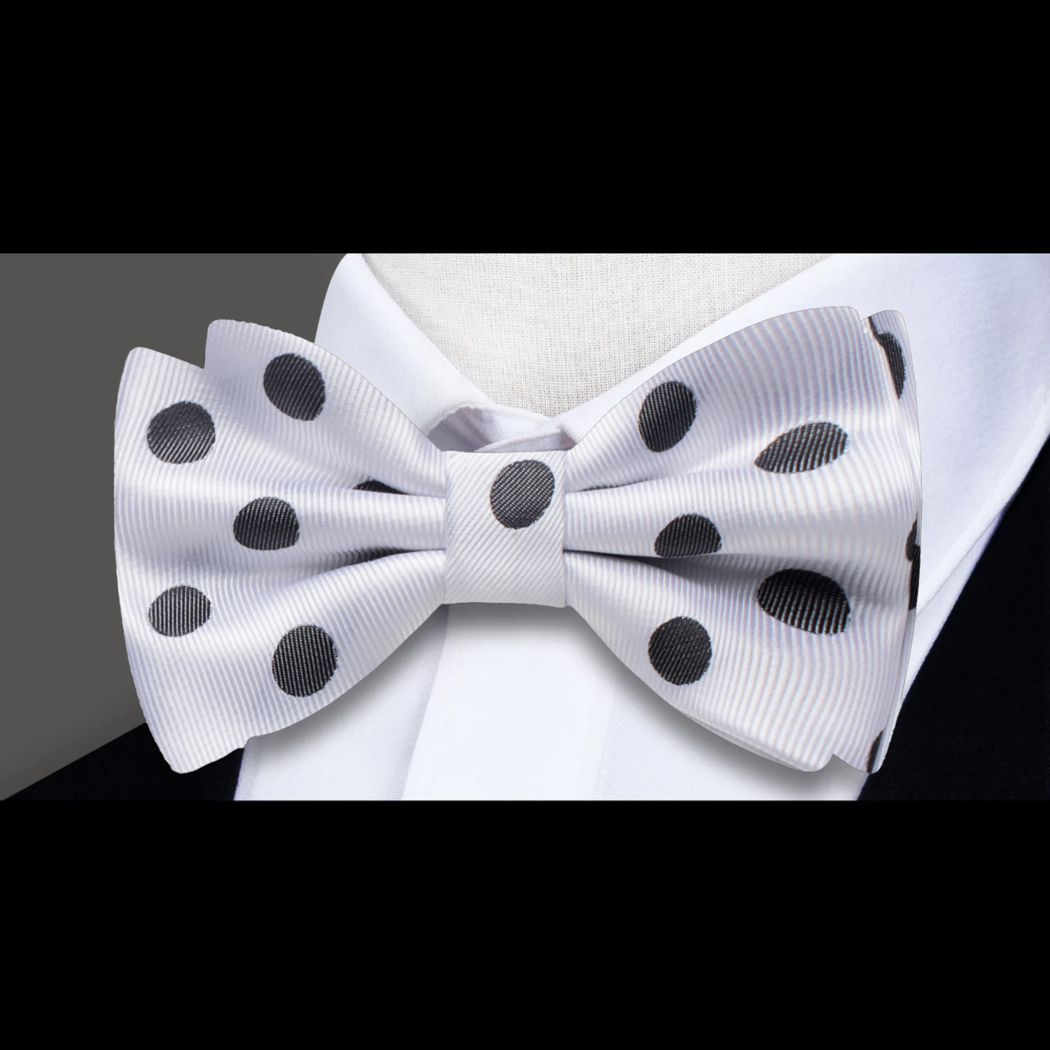 Polka dot bow tie worn with a navy suit, perfect for weddings and formal events.