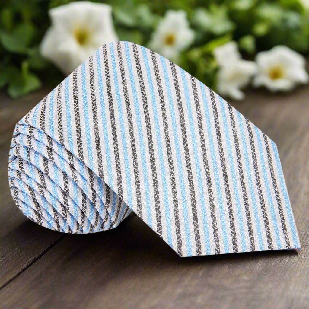 Silk tie with light blue stripes draped over a suit for weddings and business meetings