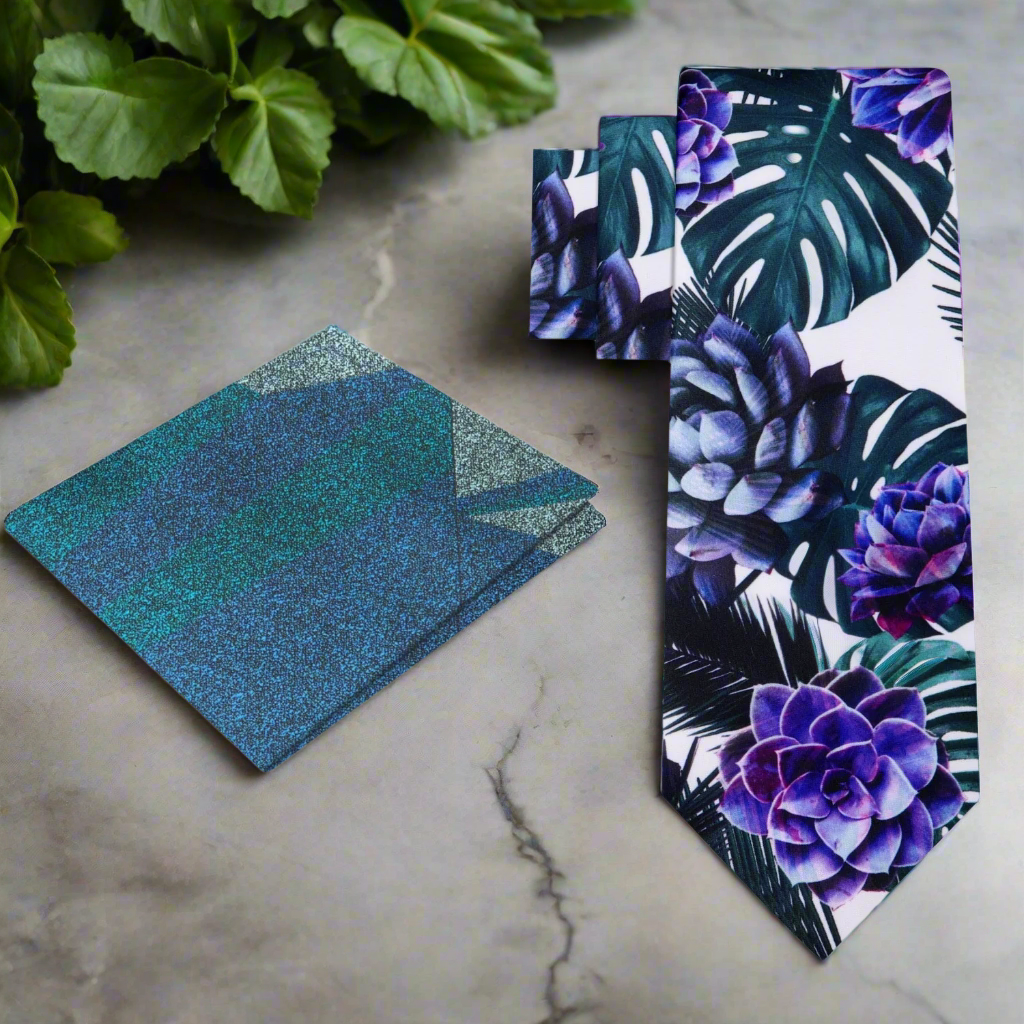 Close-up of a floral silk tie with large leaf and flower pattern in white, green, purple, and black