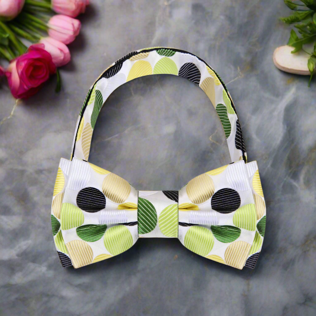 Close-up of a polka dot bow tie with green and yellow dots on white fabric