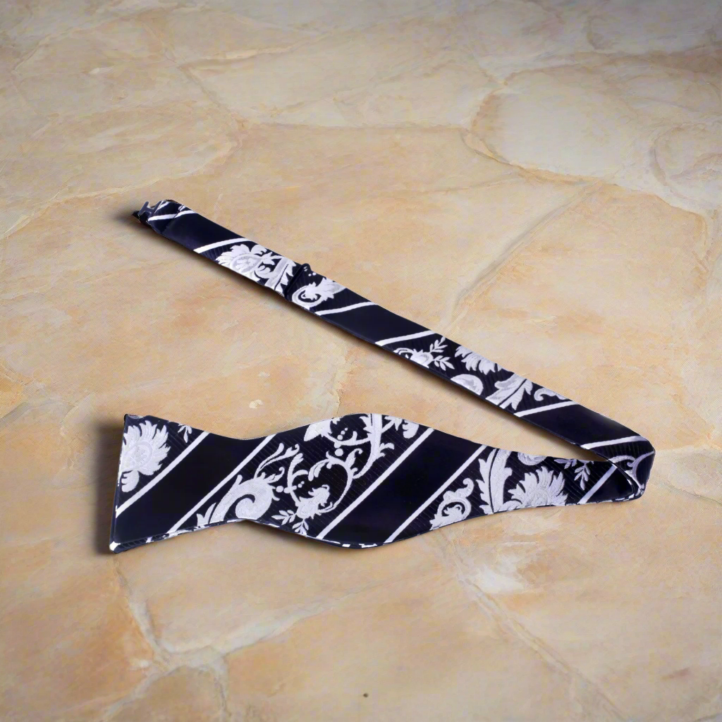 Man adjusting a silk floral bow tie with vibrant blue pattern