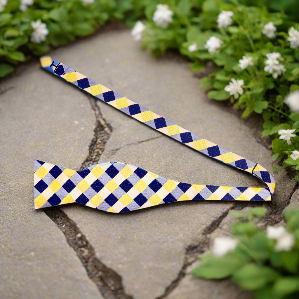 Model wearing a yellow and blue plaid bow tie paired with a light blue dress shirt.