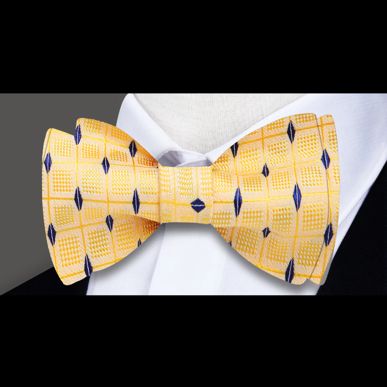 Close-up of yellow geometric self-tie bow tie in silk with diamond pattern