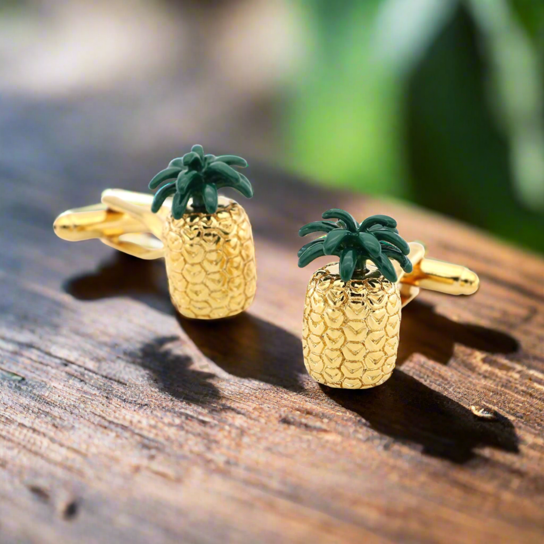 Close-up of tropical pineapple cufflinks with gold and green finish, perfect for summer events