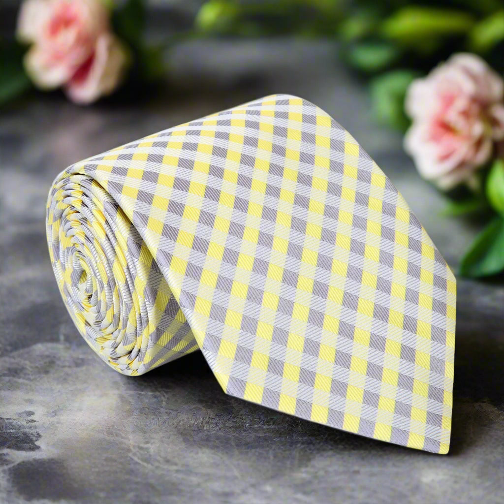 Close-up of a check pattern tie in light yellow and grey with textured silk fabric
