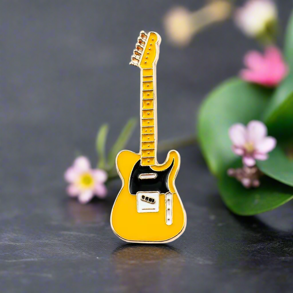 Yellow guitar lapel pin on a dress shirt, stylish accessory for musicians