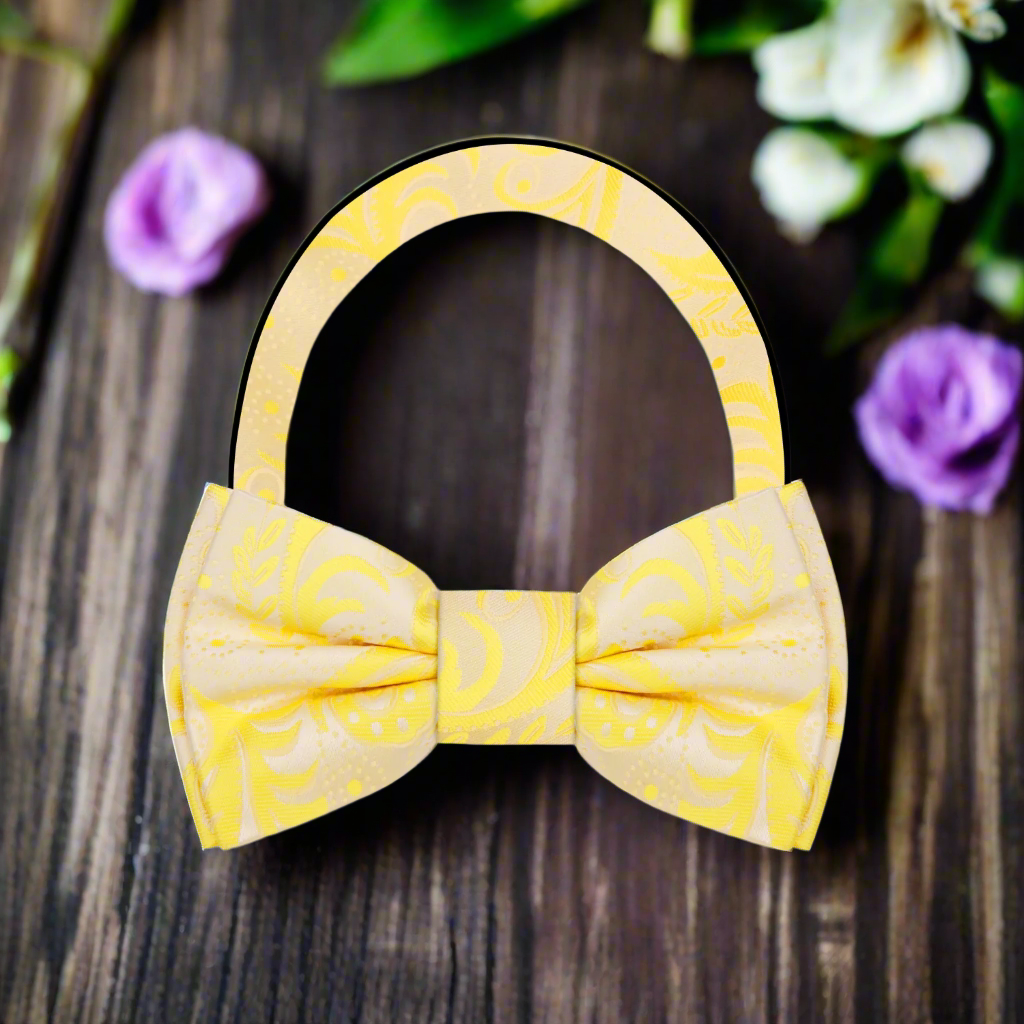 Self-tie paisley bow tie styled with a light grey suit and white shirt.