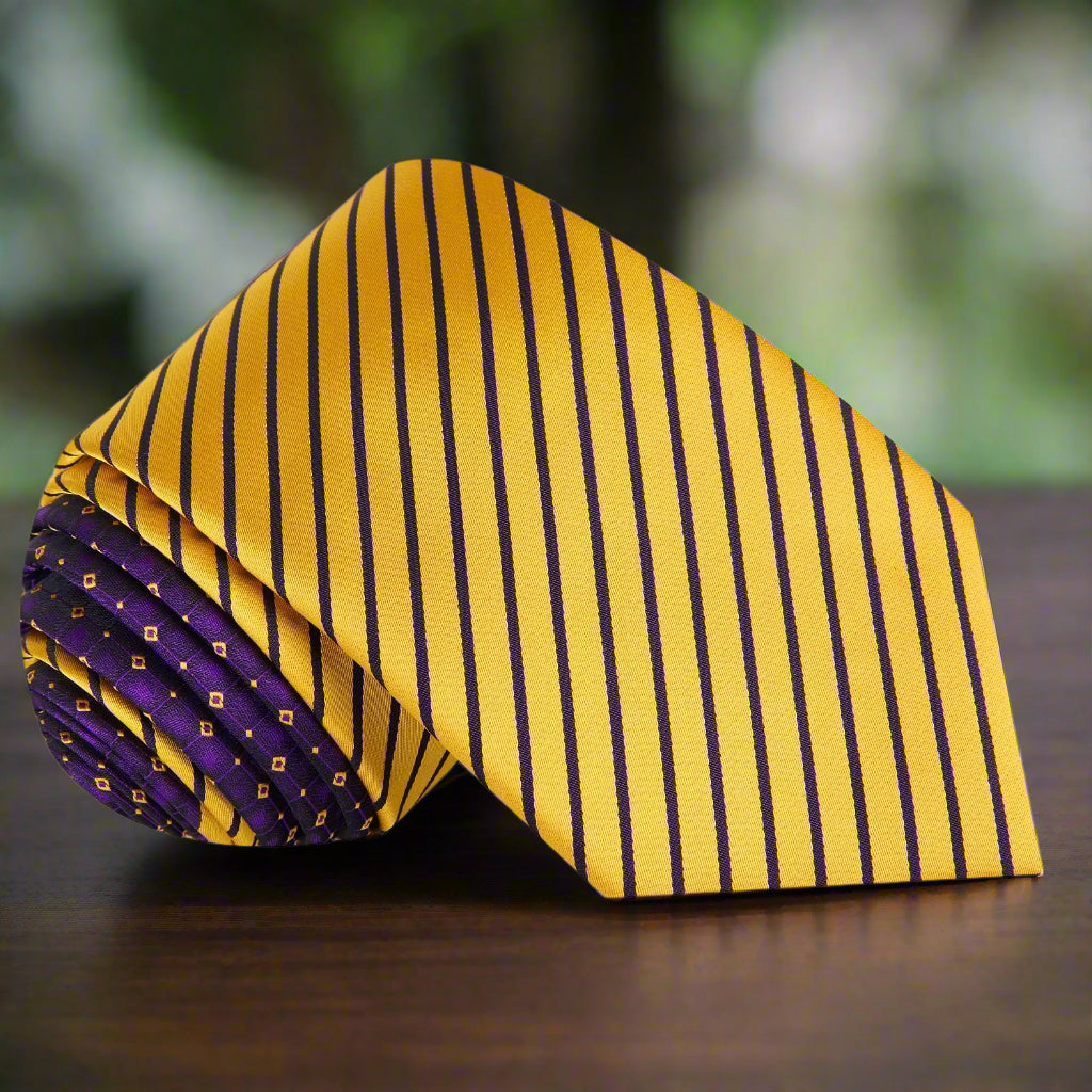 Man wearing a yellow striped tie with purple accents paired with a navy suit for a wedding or business meeting.