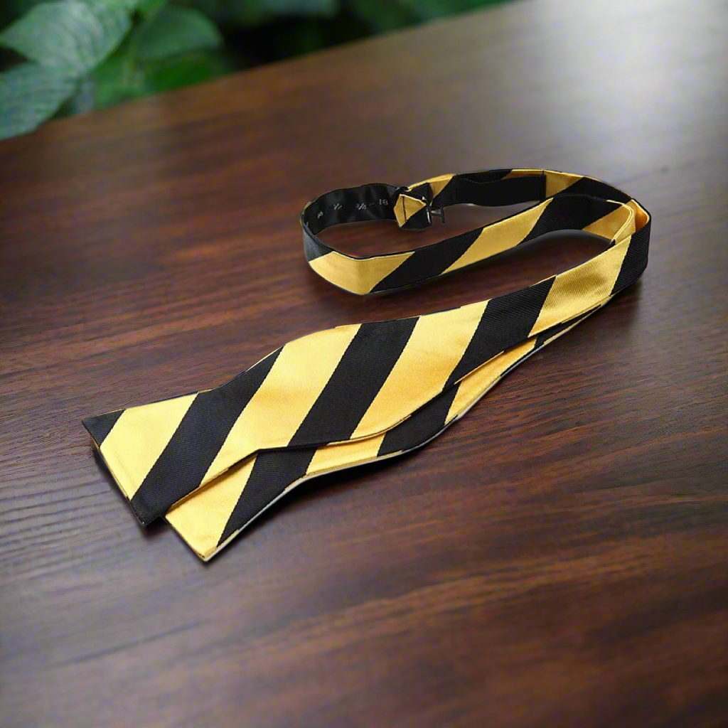 Man wearing a self-tie striped bow tie with a charcoal suit at a formal event