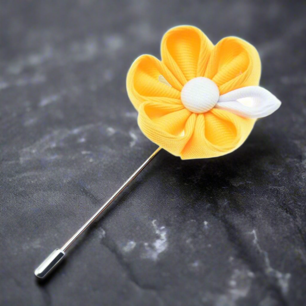 Front view of a stylish yellow and white flower lapel pin on a men's suit