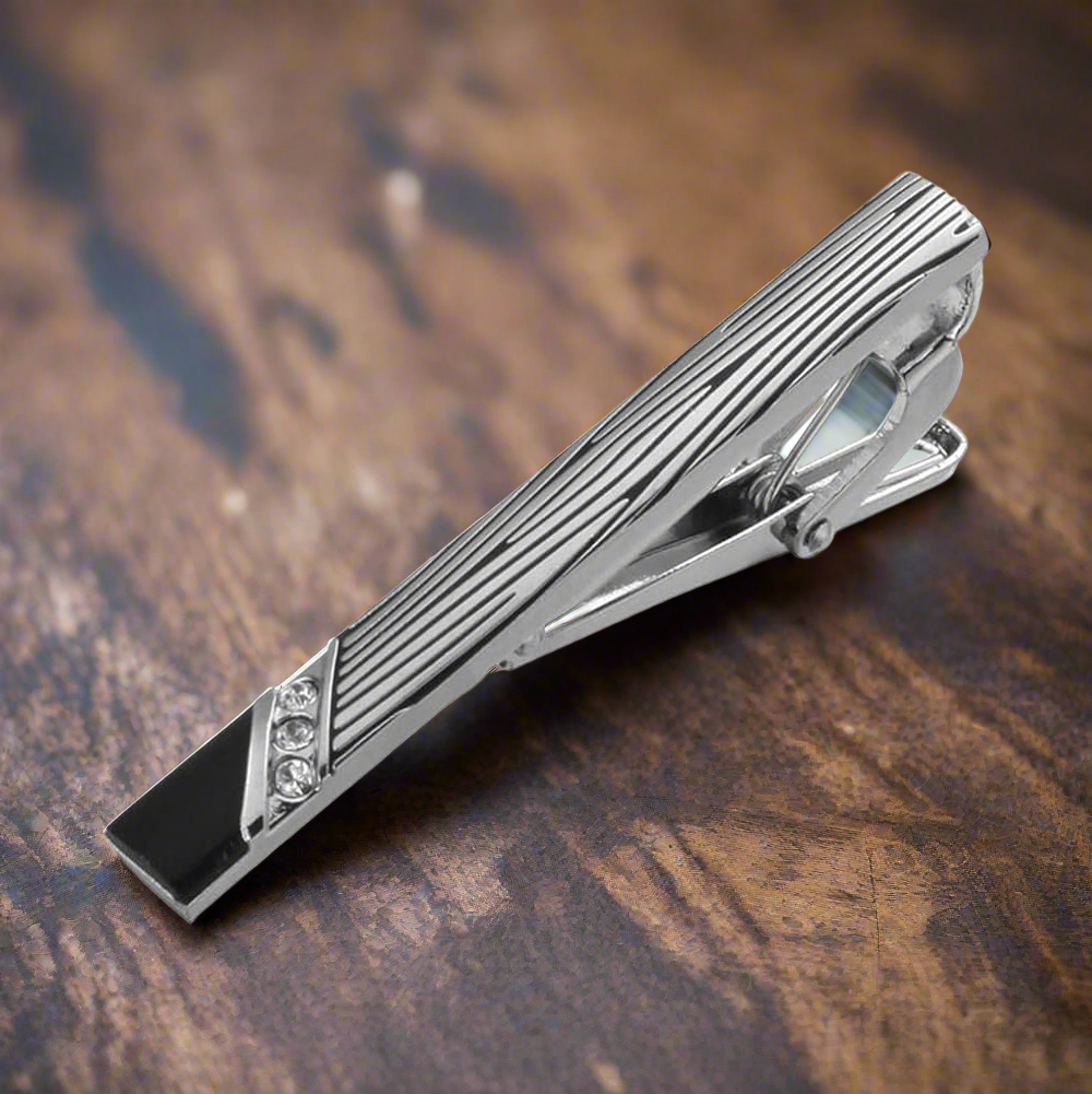 Elegant tie bar in mahogany with chrome floral design, perfect for formal occasions.