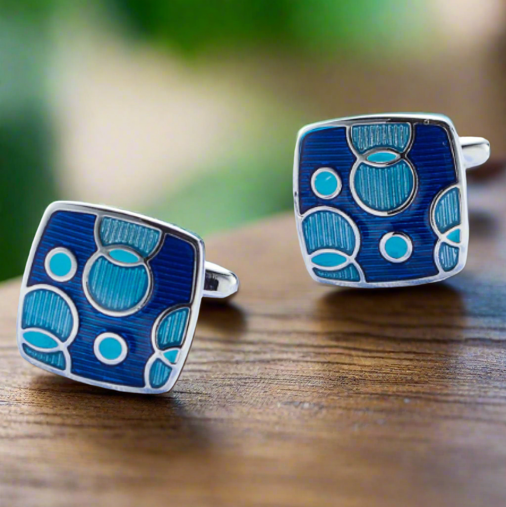 Close-up of blue and light blue circle details on square cufflinks.