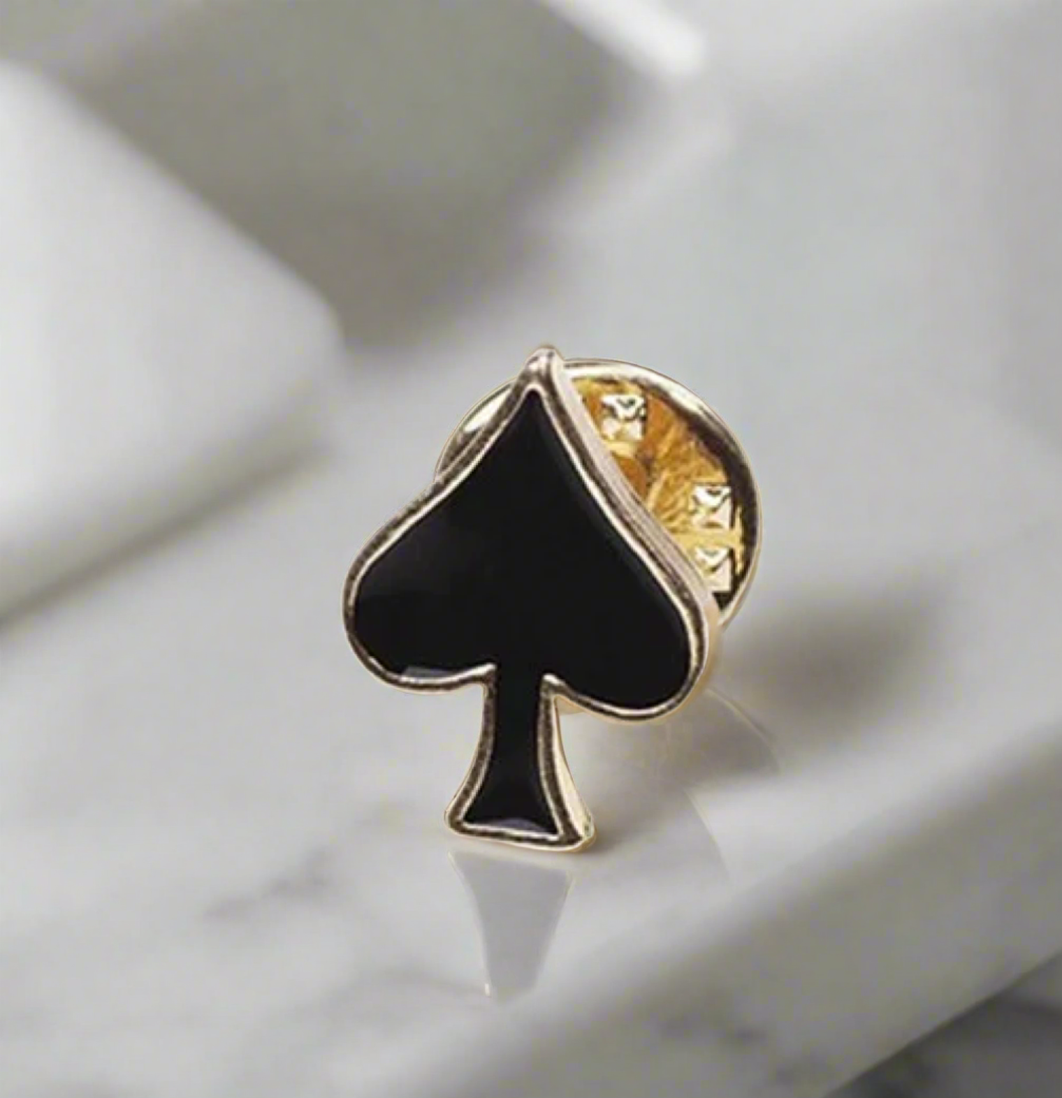 Heart lapel pin against a white dress shirt, showcasing elegance.