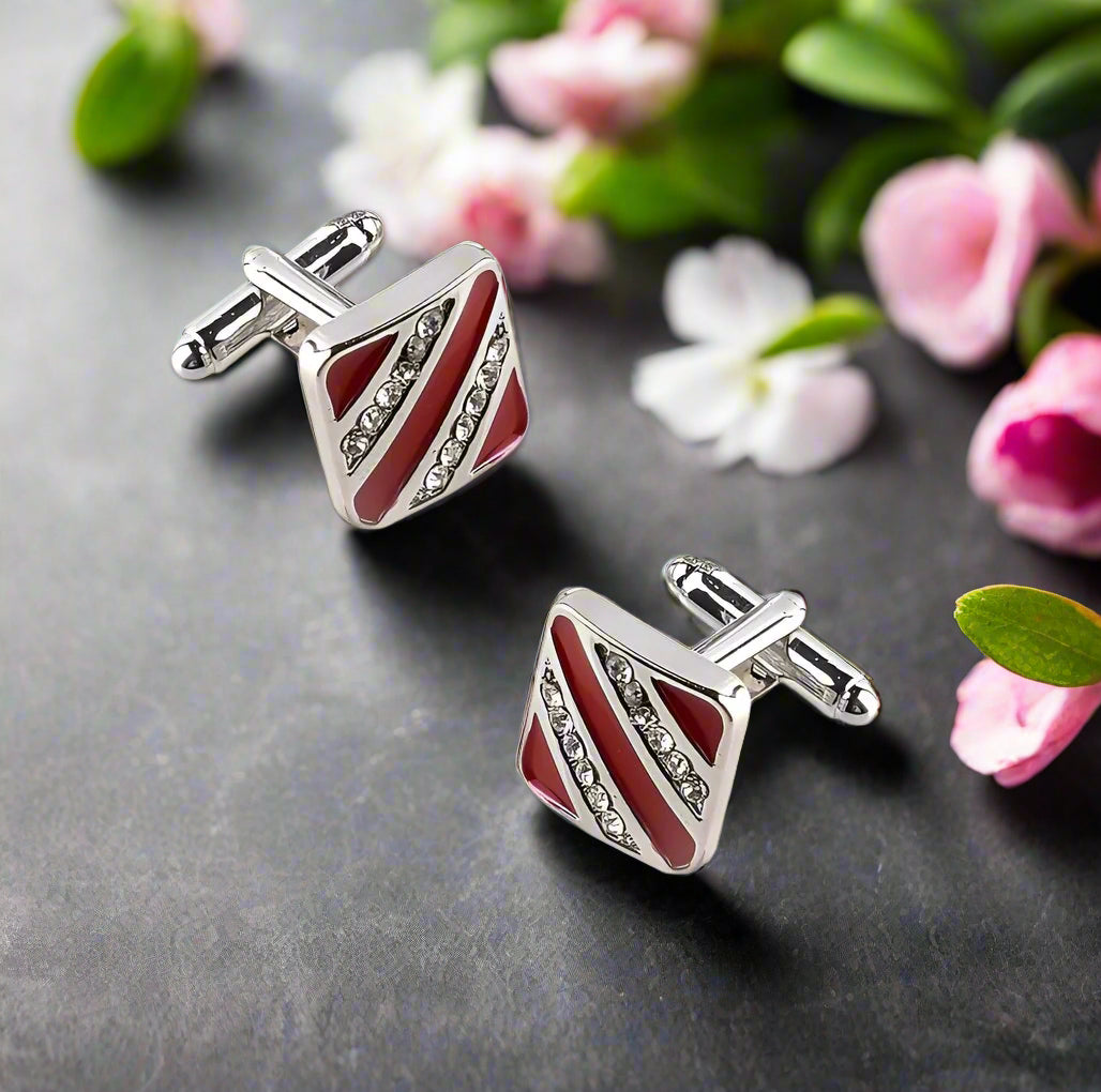 Close-up of chrome cufflinks with red stone against a black background
