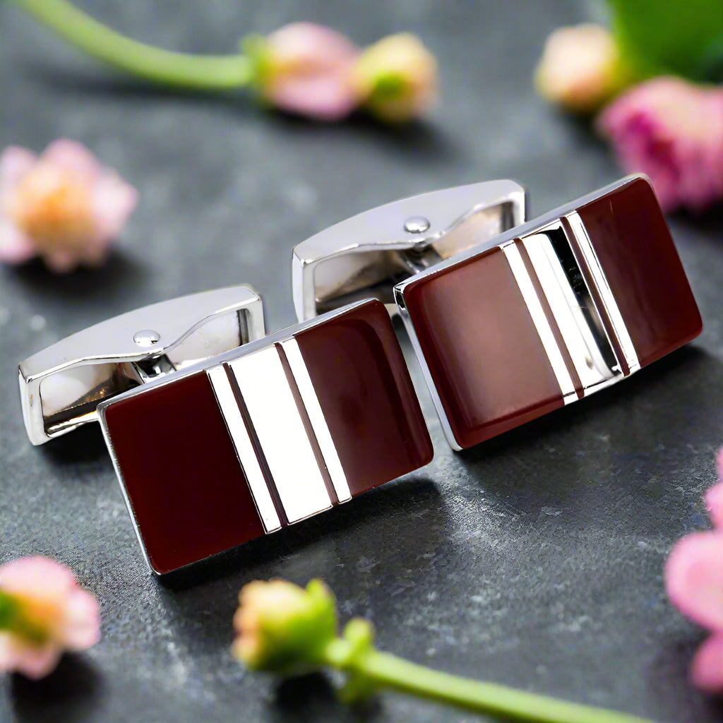 Close-up of square brown cufflink with chrome V-shape for men's accessories