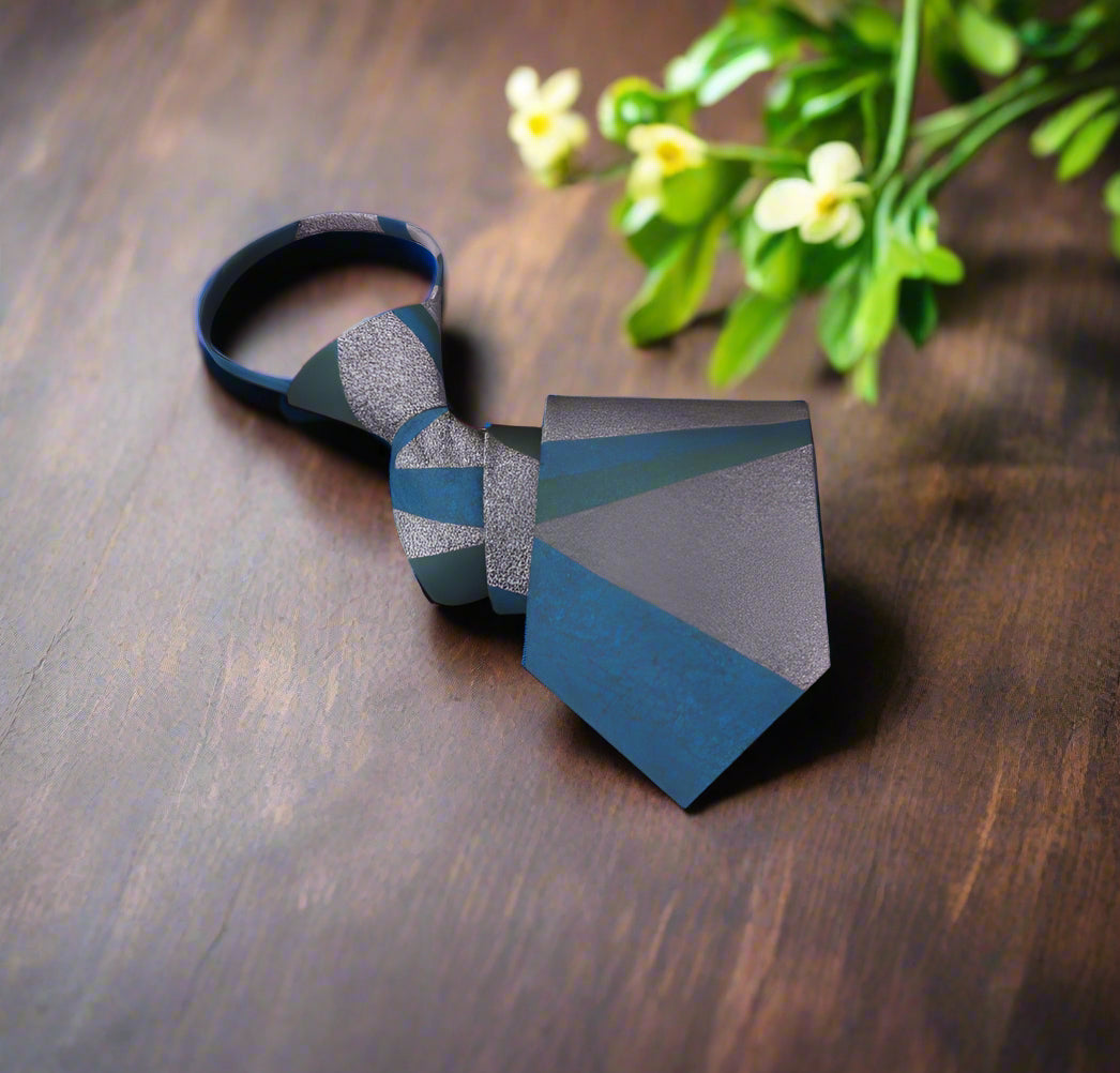 Teal silk necktie with an abstract pattern displayed on a black suit, ideal for wedding guests.