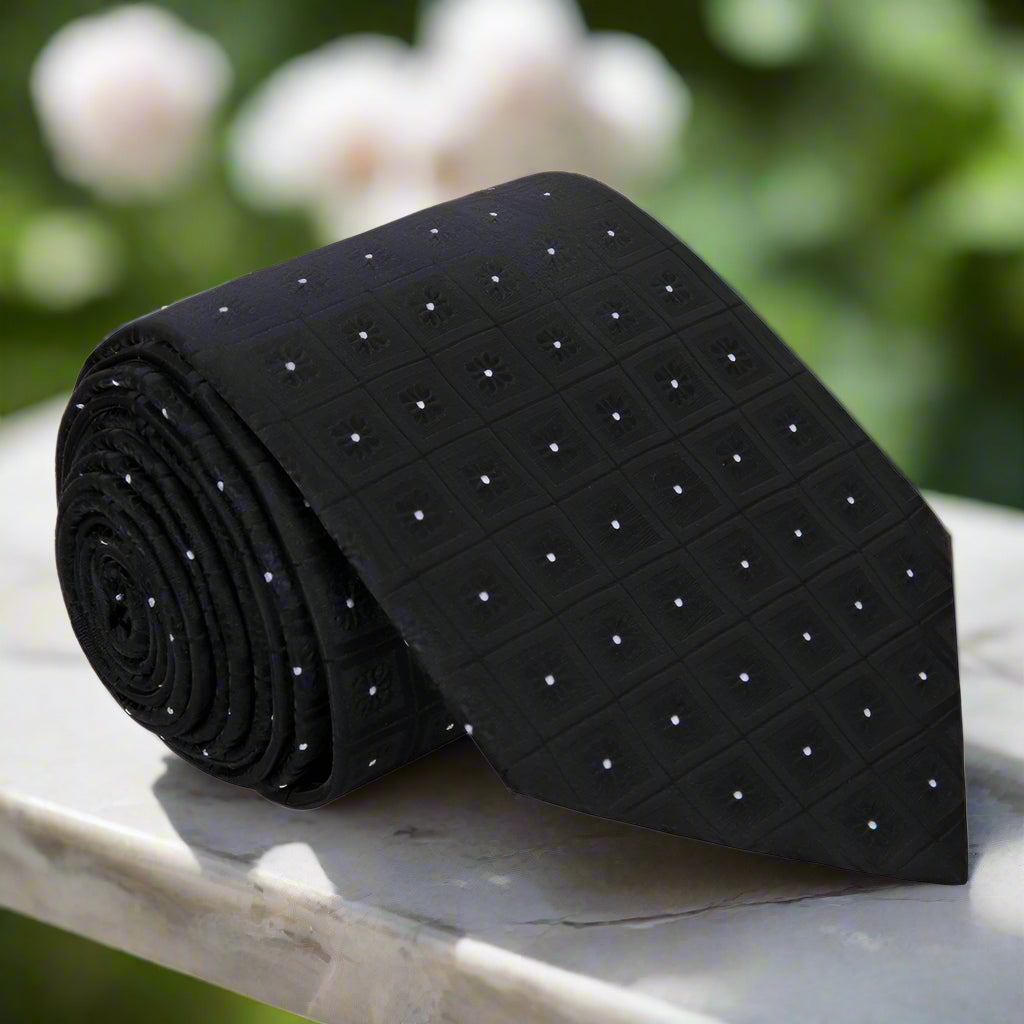 Close-up of elegant black geometric necktie with subtle patterns.