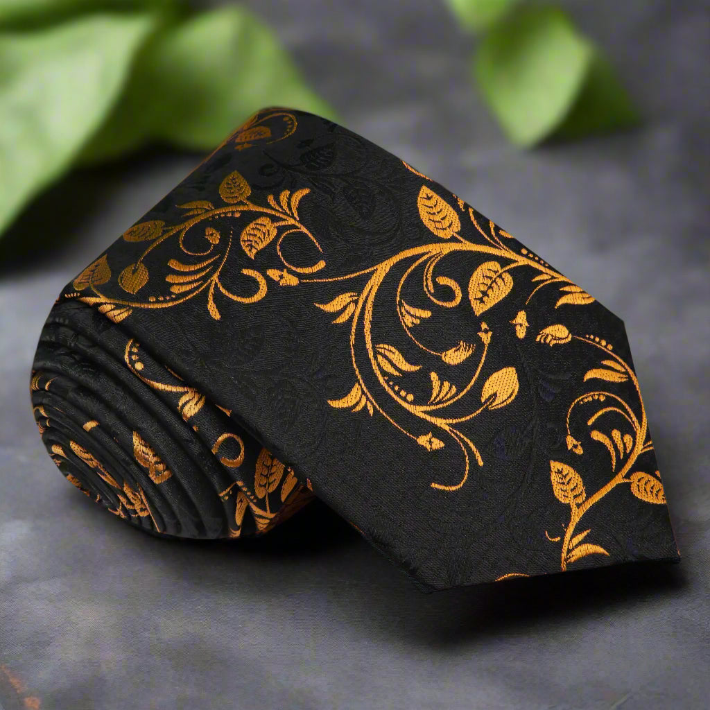 Elegant black and copper gold vine necktie draped over a suit jacket.