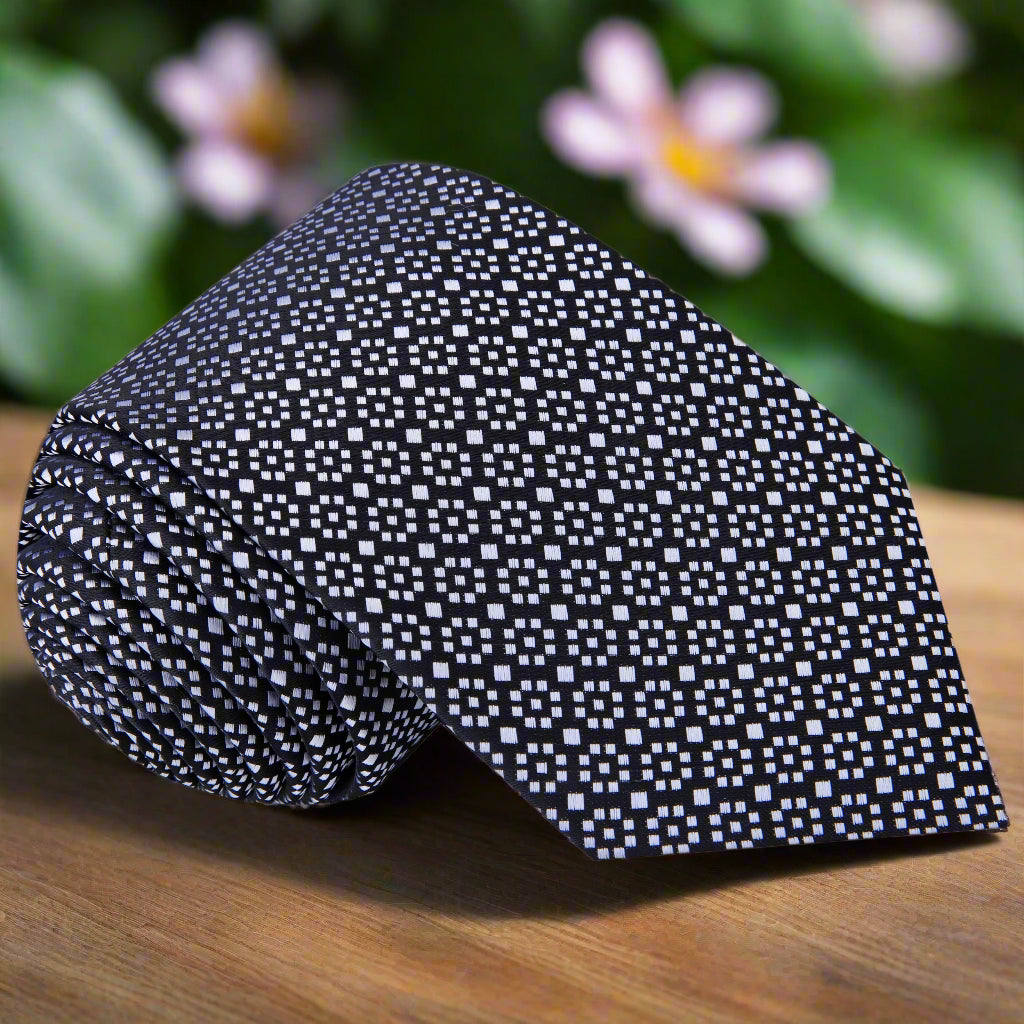 Close-up of black and grey geometric silk necktie showing pattern and texture