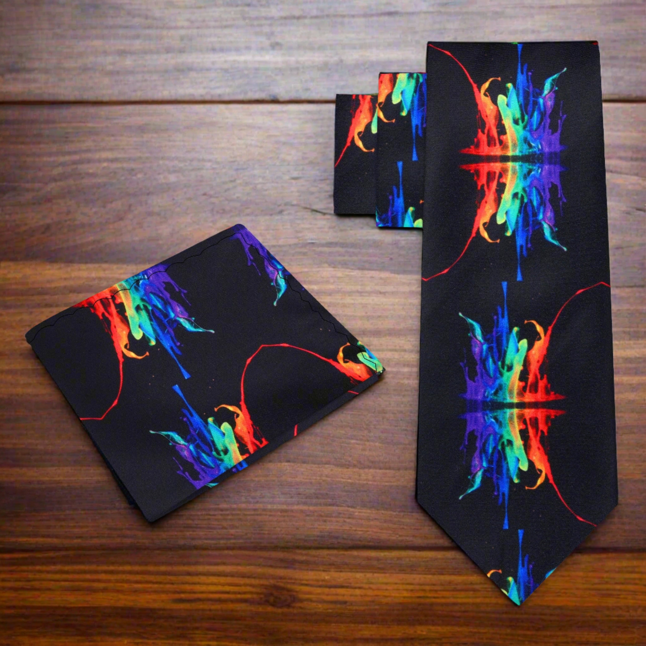 The vibrant paint splash silk tie displayed against a charcoal grey suit, showcasing its sophisticated look.