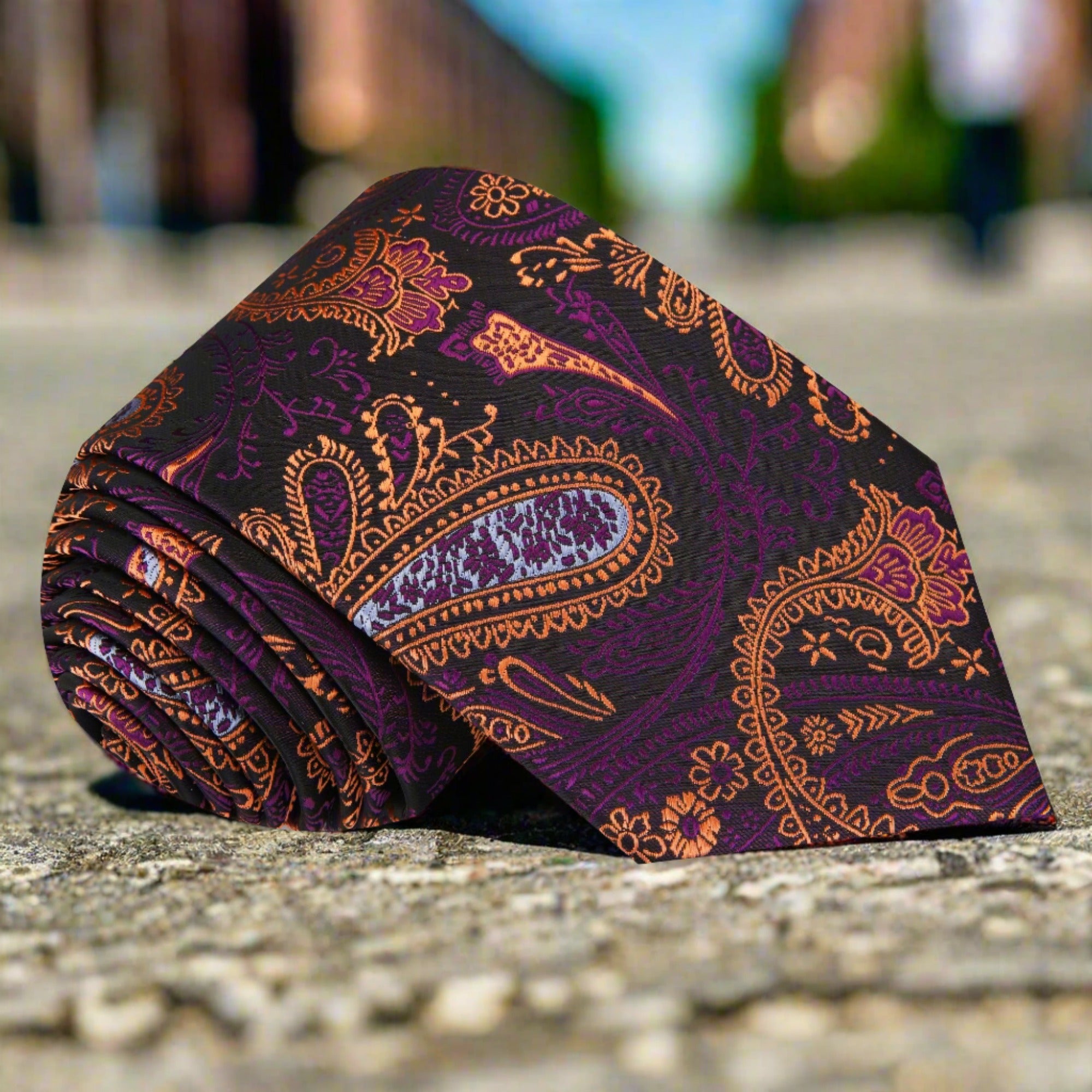 Vibrant purple paisley necktie displayed on a white shirt, showcasing its intricate design.