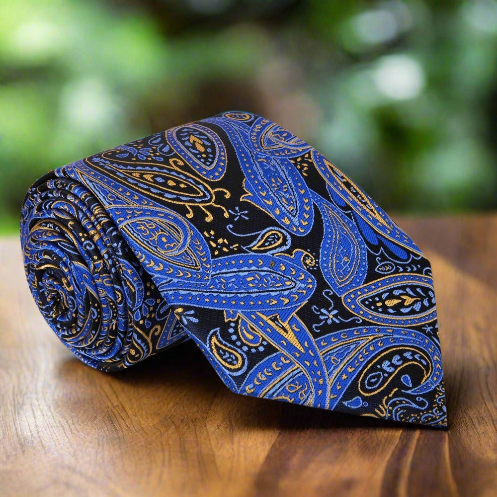 Close-up of luxury paisley tie in black and blue with yellow accents, showcasing intricate silk fabric detail.