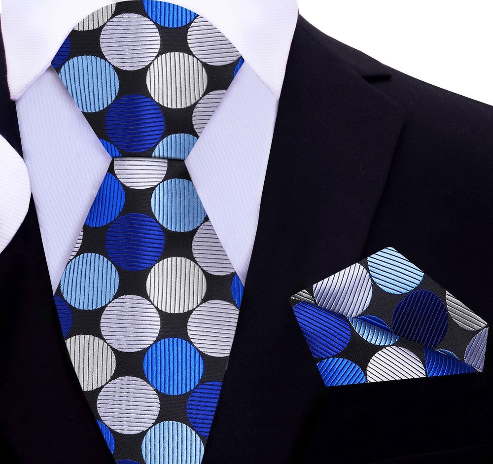 Close-up of the vibrant polka dot silk necktie, emphasizing the texture and quality of the fabric.