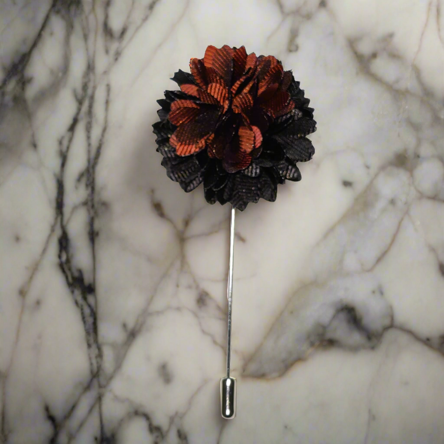 Close-up of handcrafted black and brown blossom lapel pin on suit lapel