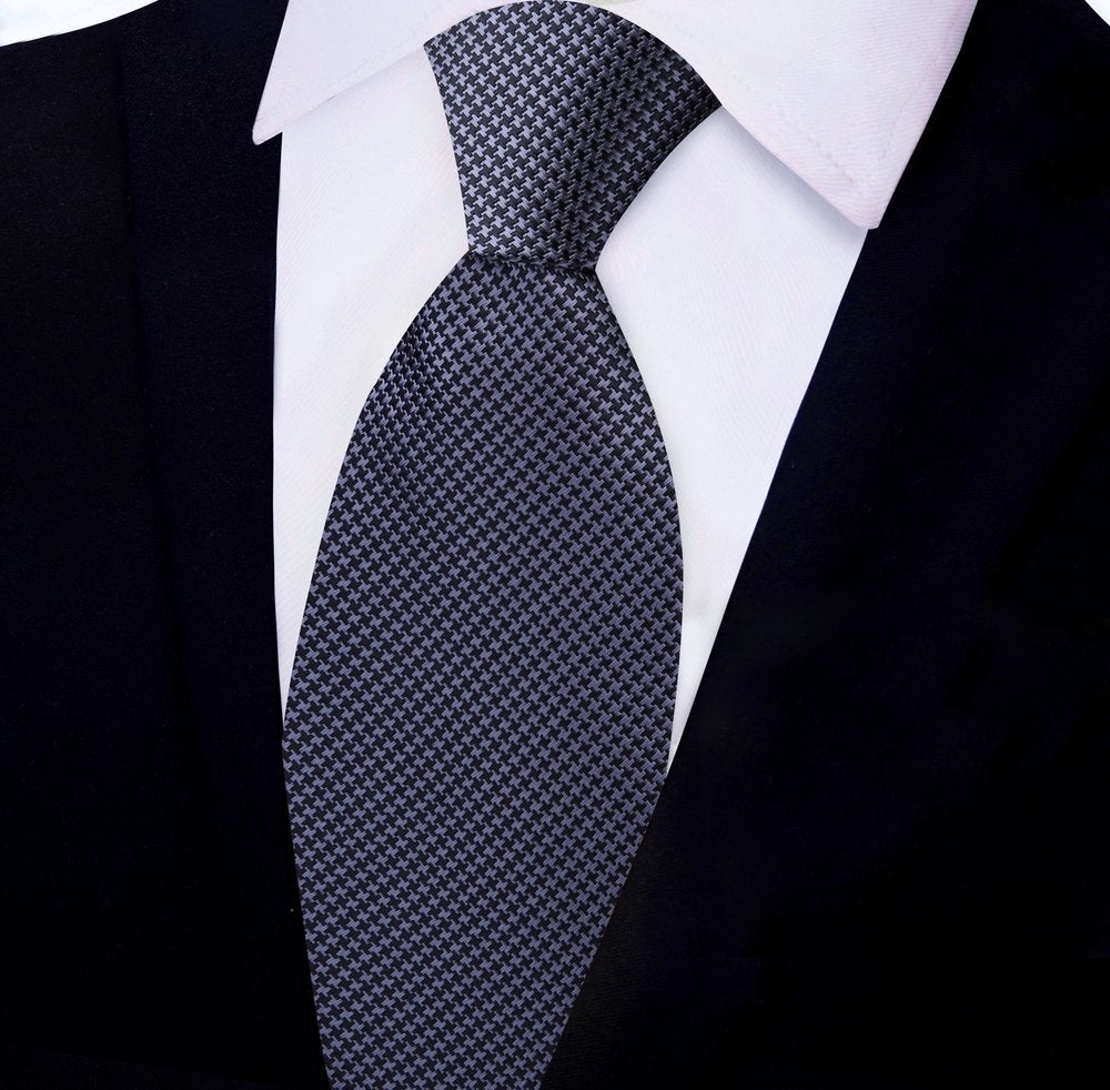 Elegant red and blue houndstooth silk tie on a white background.