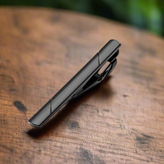 Elegant tie bar in mahogany with chrome floral design, perfect for formal occasions.