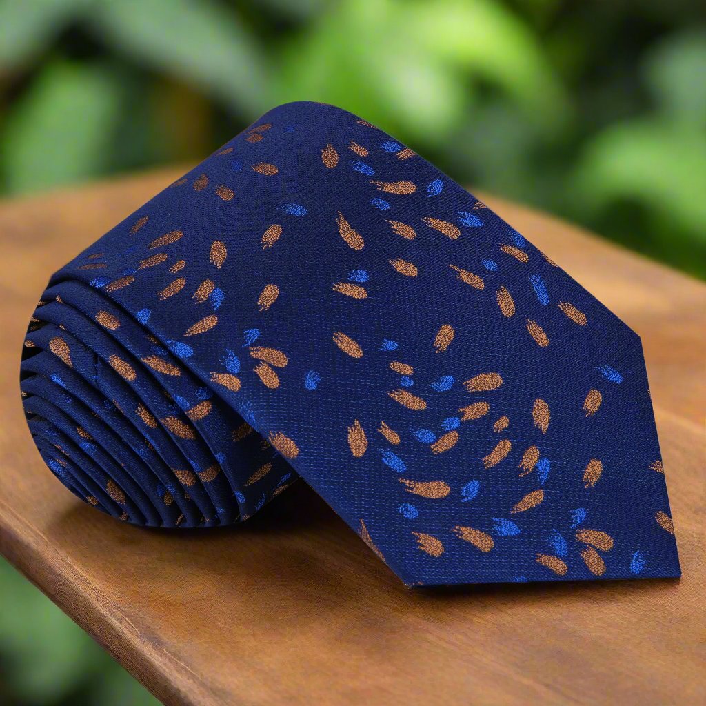 Dark blue silk tie with comet pattern displayed on a dress shirt.