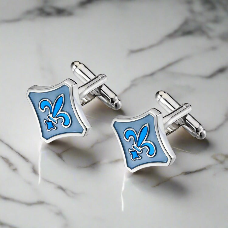 Elegant blue fleur-de-lis cufflinks with chrome finish on a white shirt cuff