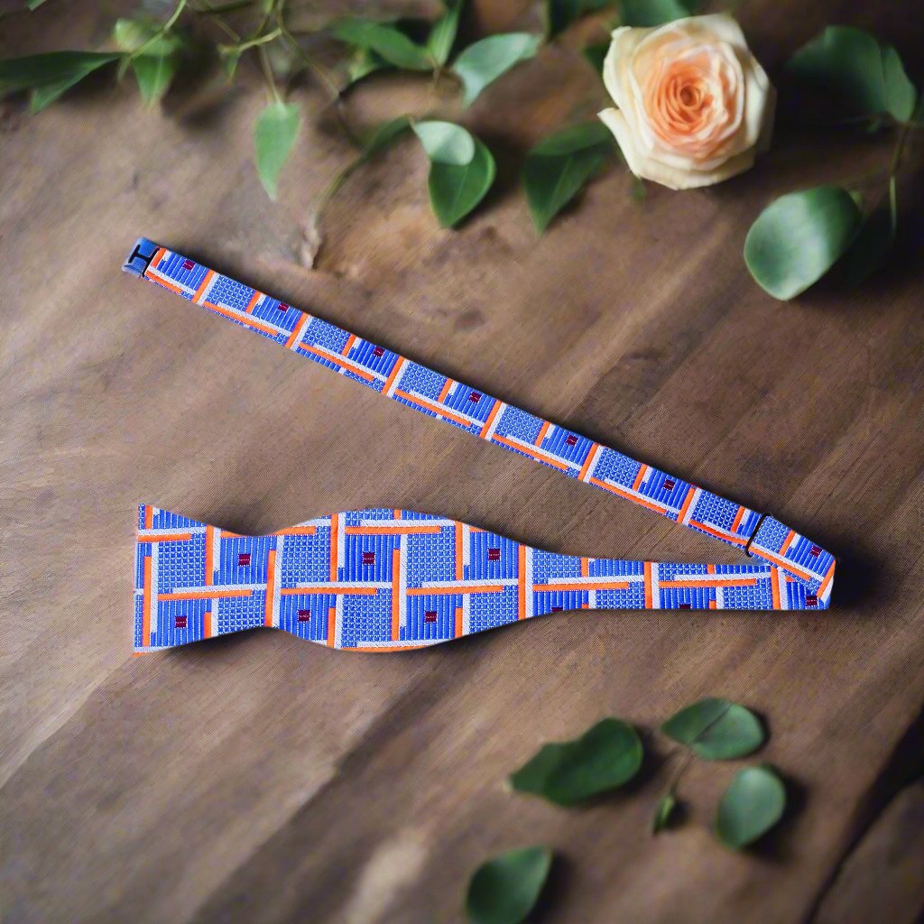 Close-up of geometric silk bow tie in blue and orange with intricate pattern