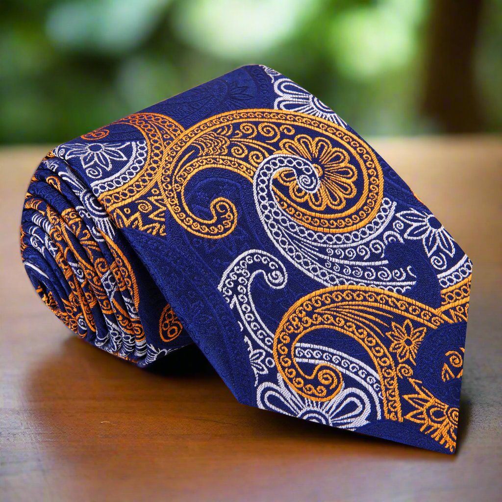 Close-up of luxury blue and gold silk paisley necktie showing detailed pattern