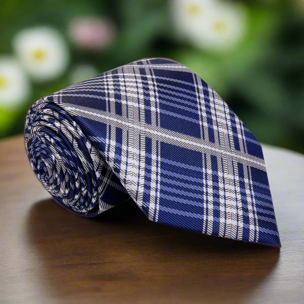 Front view of blue and grey plaid tie styled with a white dress shirt – classic men's tie look.
